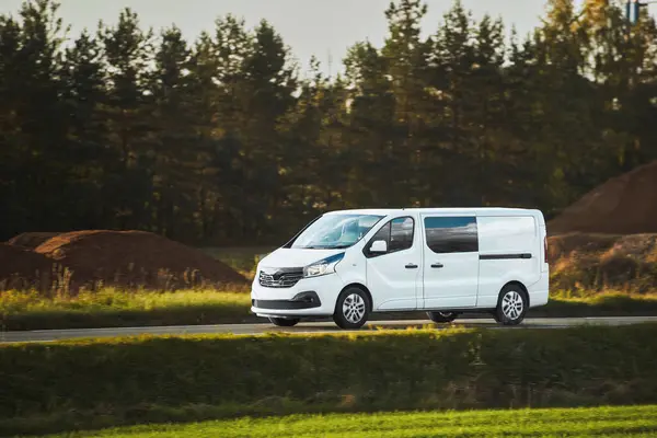 Özelleştirmen için boş ambalajı olan beyaz bir minibüsün maketi. Teslimat ve ulaşım hizmetiniz için ticari bir araç. Yolda izole edilmiş küçük beyaz bir kamyon var..