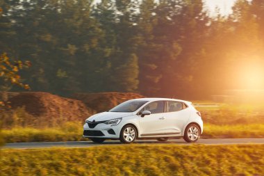 Günbatımında otoyolda izole edilmiş modern bir araç. Sunny Highway 'de lüks bir arabayla yaz tatilinin tadını çıkarıyorum.