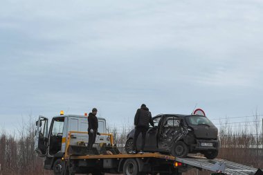 02.02.2024 Polonya, Avrupa. T-Bone araba kazası. Modern aile arabası kaza yaptı. Yolunda bozuk bir araba olan çekici. Çekici, otobana bir araba yüklüyor. Trafik kazası bölgesi.