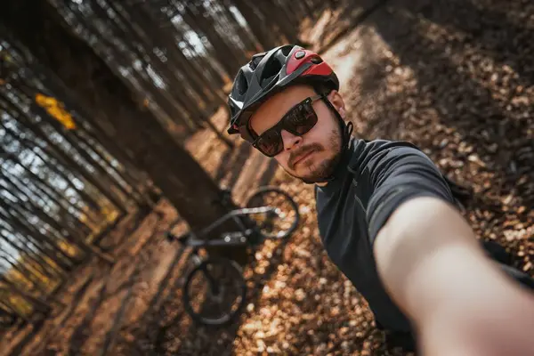 Güneş gözlüklü ve Kasklı Sportif ve Maceraperest Adam Bisikletli Kendi Fotoğrafını Çekiyor