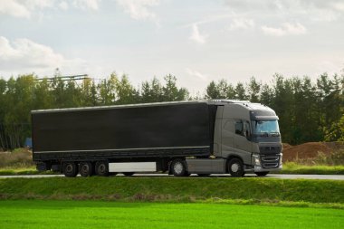 Mal teslimatı ve nakliyesi yarı karavan kamyonlarıyla. Kamyonlar kargo konteynırlarıyla yolda ilerliyorlar. Sürdürülebilir ve verimli ulaşım sistemi kavramı. Arazi lojistik endüstrisi modeli.