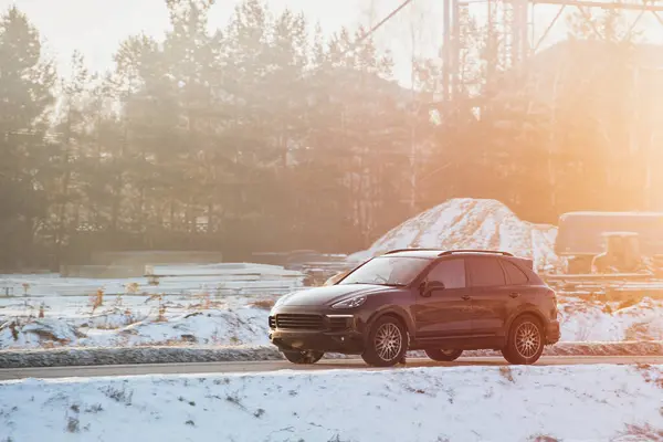 Luxury Performance Meets Winter Terrain. Black German SUV Embraces the Snowy Road.