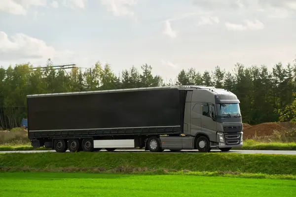 セミトライラートラックによる商品の配送と発送 トラックは貨物の容器が付いている道を運転します 持続可能で効率的な輸送システムの概念 ランドロジスティクス業界モックアップ ストック写真