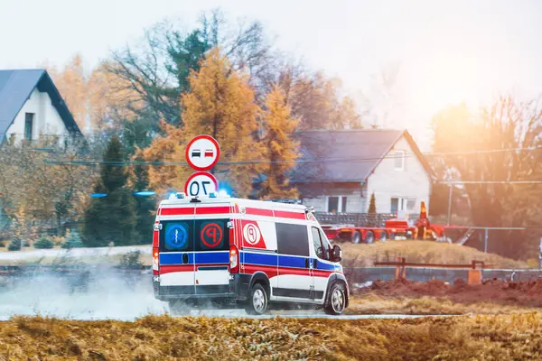 Emergency Response in Action as an Ambulance Travels Quickly on a Wintry Road Amidst Nature