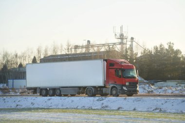 Kışın karla kaplı bir otoyolda kargo taşımak. Nakliye kamyonu kaygan ve tehlikeli bir yoldan yarı römork sürüyor. Hava buz gibi ve karlı..