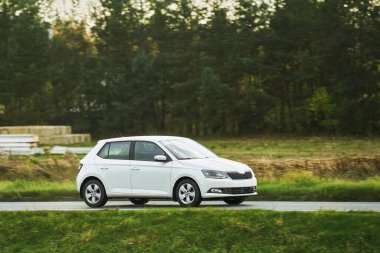 Günbatımında otoyolda izole edilmiş modern bir araç. Sunny Highway 'de lüks bir arabayla yaz tatilinin tadını çıkarıyorum.