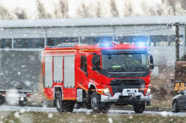 Bir acil durum aracı yolda hızlı gider. İtfaiyecileri ve itfaiye ekipmanlarını taşıyan bir itfaiye aracı yangına ya da kazaya doğru gidiyor. Araç trafikte ilerlerken siren sesleri.