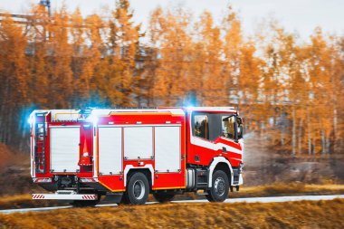 Bir acil durum aracı yolda hızlı gider. İtfaiyecileri ve itfaiye ekipmanlarını taşıyan bir itfaiye aracı yangına ya da kazaya doğru gidiyor. Araç trafikte ilerlerken siren sesleri.