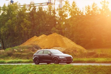 Güzel bir ormanla çevrili, Manzaralı bir yolda giden bir araba.