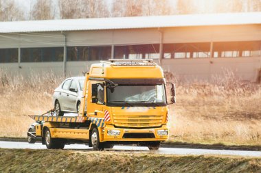 Bir köy yolundaki yol kenarı yardım servisi. Bir çekicinin taşıdığı araba bir trafik kazasına karıştı ve bozuk bir motoru var.