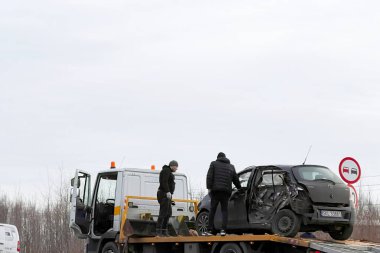 02.02.2024 Polonya, Avrupa. Çarpışmadan sonra otobanda hasarlı bir siyah hatchback arabasını yükleyen bir çekici. Toyota 'ya başka bir araç çarptı ve ağır hasar aldı. Toplam kayıp araba