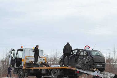 02.02.2024 Polonya, Avrupa. Toyota Yaris T-Bone araba kazası. Modern aile arabası kaza yaptı. Yolunda bozuk bir araba olan çekici. Çekici yolda bir hatchback yüklüyor. Araba kazası alanı.
