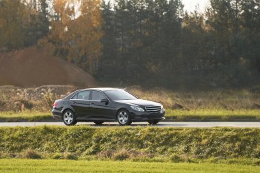 Güneşli bir otoyolda yeni ve hızlı bir araba sürüyorum Güzel bir manzarası olan