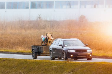 Çamur kaplı motokros motosikletli bir karavanı çeken araba doğanın ortasındaki bir sonraki maceraya hazır.