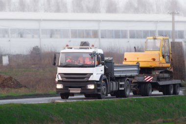 Kazıcı Taşımacılığı Flatbed Truck tarafından Şehir İnşaat Alanına Taşıtıldı