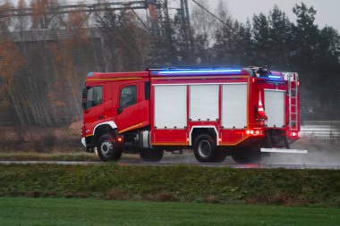 Bir itfaiye aracı yangın yerine doğru koşuyor. Gemideki itfaiyeciler hayat kurtarmaya ve alevleri söndürmeye hazırlar. Araç şehir sokaklarında hızla ilerlerken siren çalıyor..