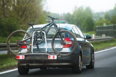 Car with bikes securely attached to a rear rack, ready for an outdoor adventure for the whole family and friends.