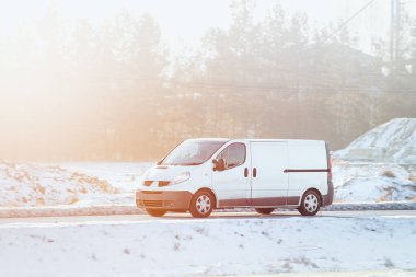 Teslimat minibüsü güneşli bir yol boyunca paketler taşır, tam zamanında hizmet ve müşteri memnuniyetini sağlar.