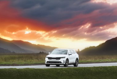 Beyaz modern SUV taşra yolunda hızla ilerliyor.