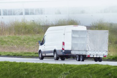 Güneşli kırsal yolda araba nakliye karavanı