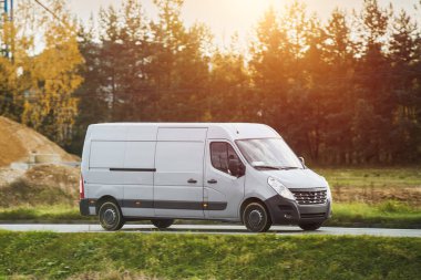 Beyaz minibüs köy yolunda hız yapıyor.