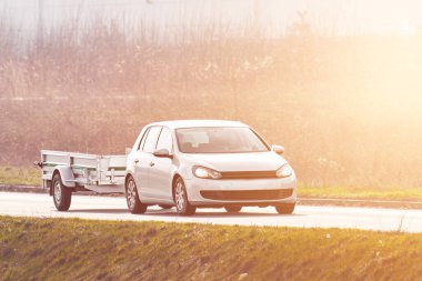 Parlak kırsal yolda çekici römorku var.