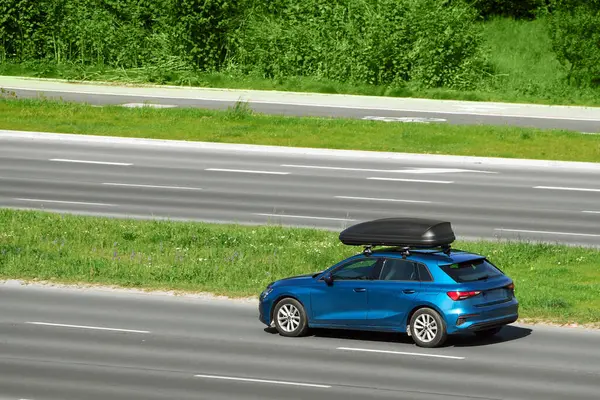 stock image view of a moving car equipped with a rooftop cargo carrier in city traffic