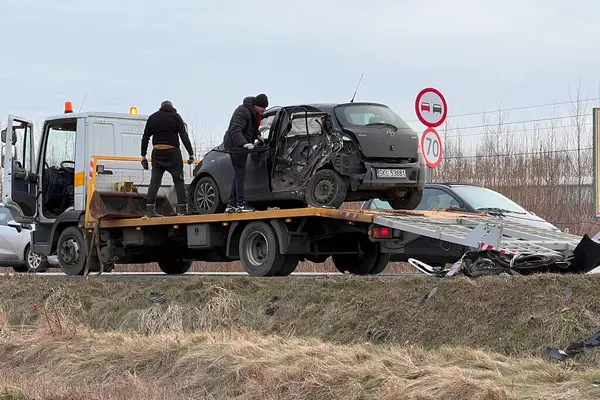 02.02.2024 Polonya, Avrupa. Çarpışmadan sonra otobanda hasarlı bir siyah hatchback arabasını yükleyen bir çekici. Toyota 'ya başka bir araç çarptı ve ağır hasar aldı. Toplam kayıp araba