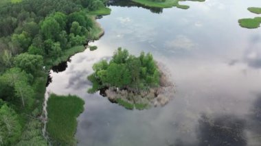 Ağaç adası ve gökyüzü su yüzeyini yansıtıyor.
