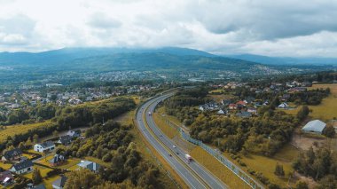Evleri olan yemyeşil bir arazide dolambaçlı yol manzarası