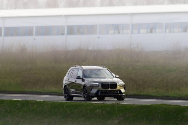 Lüks pahalı aile arazi aracı kırsal yolda gidiyor.