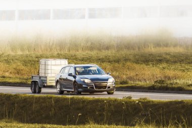 Güneşli kırsalda araba çekme karavanı