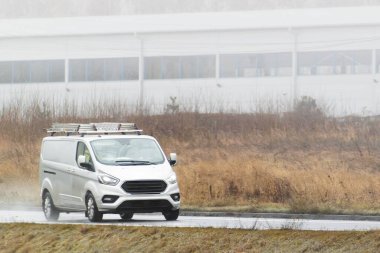 Ekipman ve malzemelerle yola çıkan ticari bir minibüs.