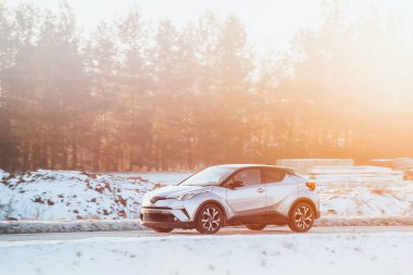 Kırsal bir yolda son sürat giden şık bir araba.