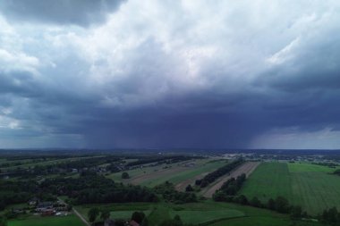 Yeşil tarlalı kırsal alana yaklaşan kara fırtına.