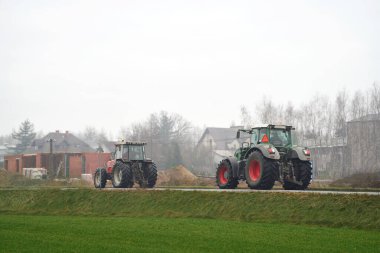 Traktör asfalt yolda çiftçilik hedefine gidiyor.