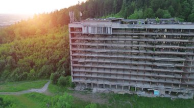 Ağaçlarla çevrili terk edilmiş bir otel.