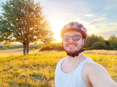Bisikletçi tarlada dağ bisikletiyle selfie çekiyor.