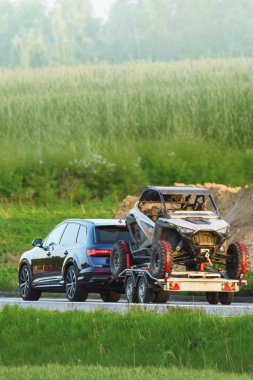 Kırsal kesimde SUV tarafından taşınan karavandaki at arabası.