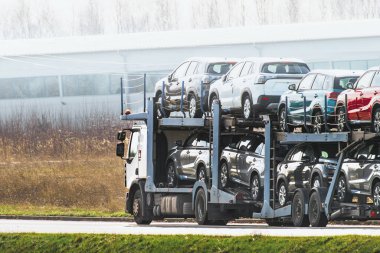 Müşteriler için çok sayıda yeni SUV taşıyan bir kamyon