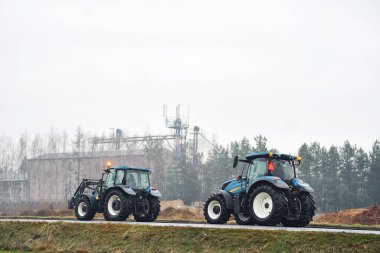 Traktör asfalt yolda çiftçilik hedefine gidiyor.