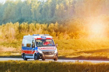 Yeşil arazide ilerleyen bir ambulans.