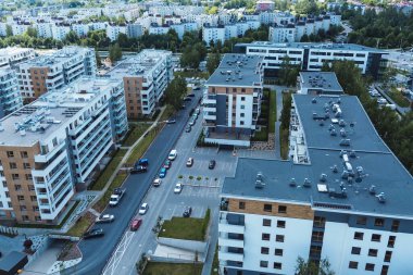 Çağdaş alçak katlı apartmanlar yeşilliklerle çevrili.