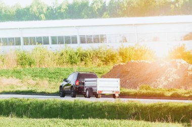 Araba kapalı bir karavanı dışarı çekiyor.