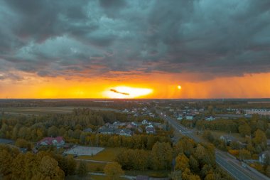 Fırtına bulutları ve gün batımı ışığıyla kırsal manzara