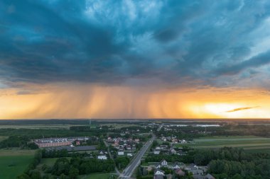 Yaklaşan fırtına bulutlarıyla kırsal arazide gün batımı