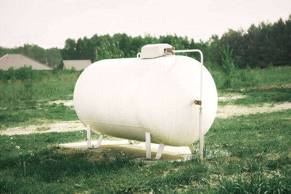 Large white propane gas tank providing clean energy to a rural home