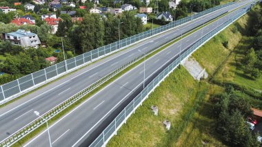 Arabalar ve kamyonlar Gürültü Duvarından geçiyor