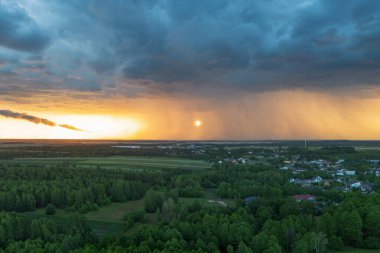 Altın saat ışığı kırsal kesimde kara bulutlara zıt düşüyor