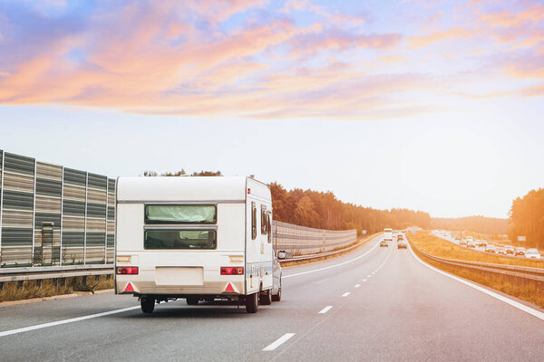 Old camper van cruising down empty road